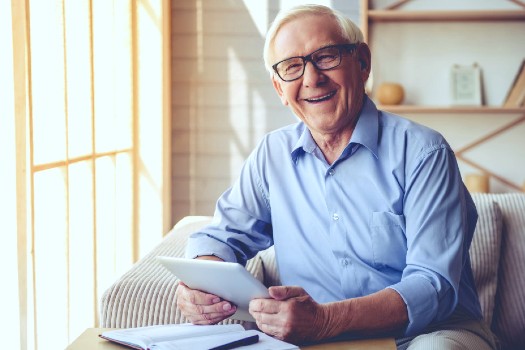 Photo of senior gentleman on his tablet at Fellowship Square senior living in Mesa