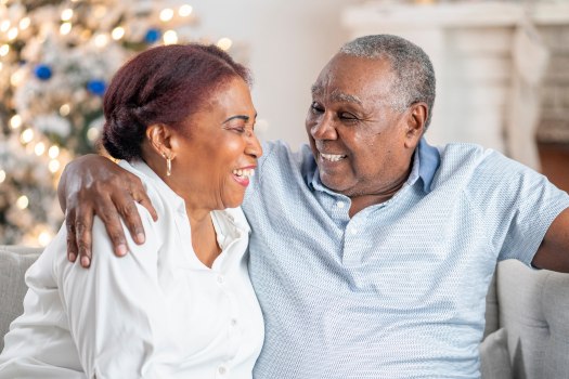 Senior couple laughing in front of the Christmas tree