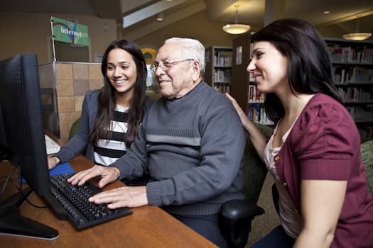 people showing person how to use computer