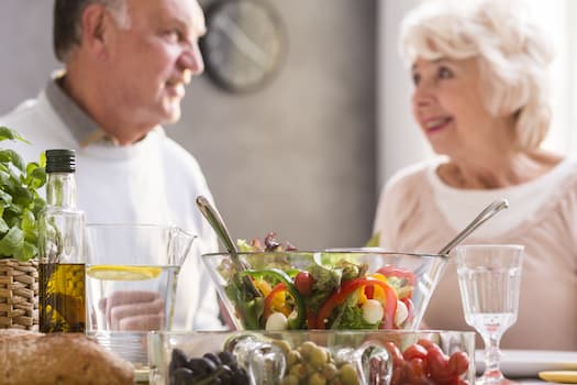 couple sitting in front of salad bowl