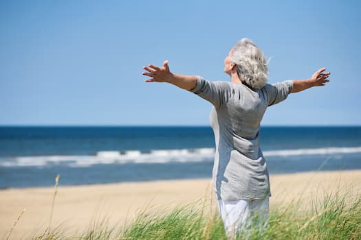 Person on beach with arms stretched wide