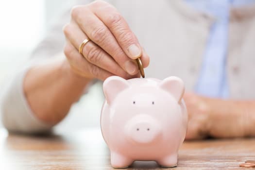 Hand putting coin in piggy bank