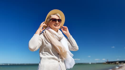 woman in hat and sunglasses on beach